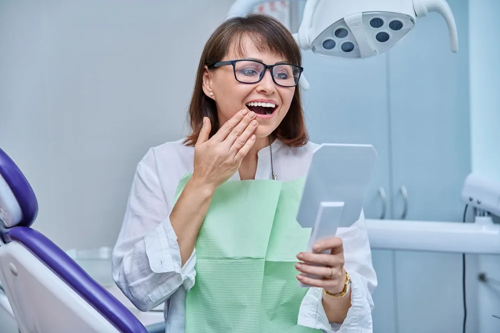 A patient viewing their smile in a mirror
