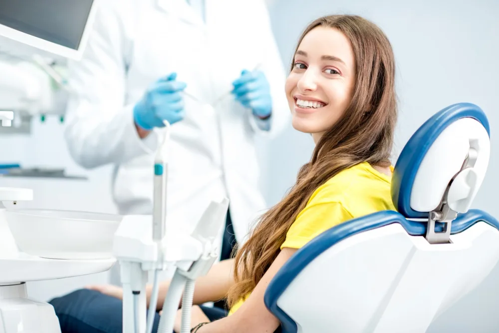 A smiling dental patient in a treatment room